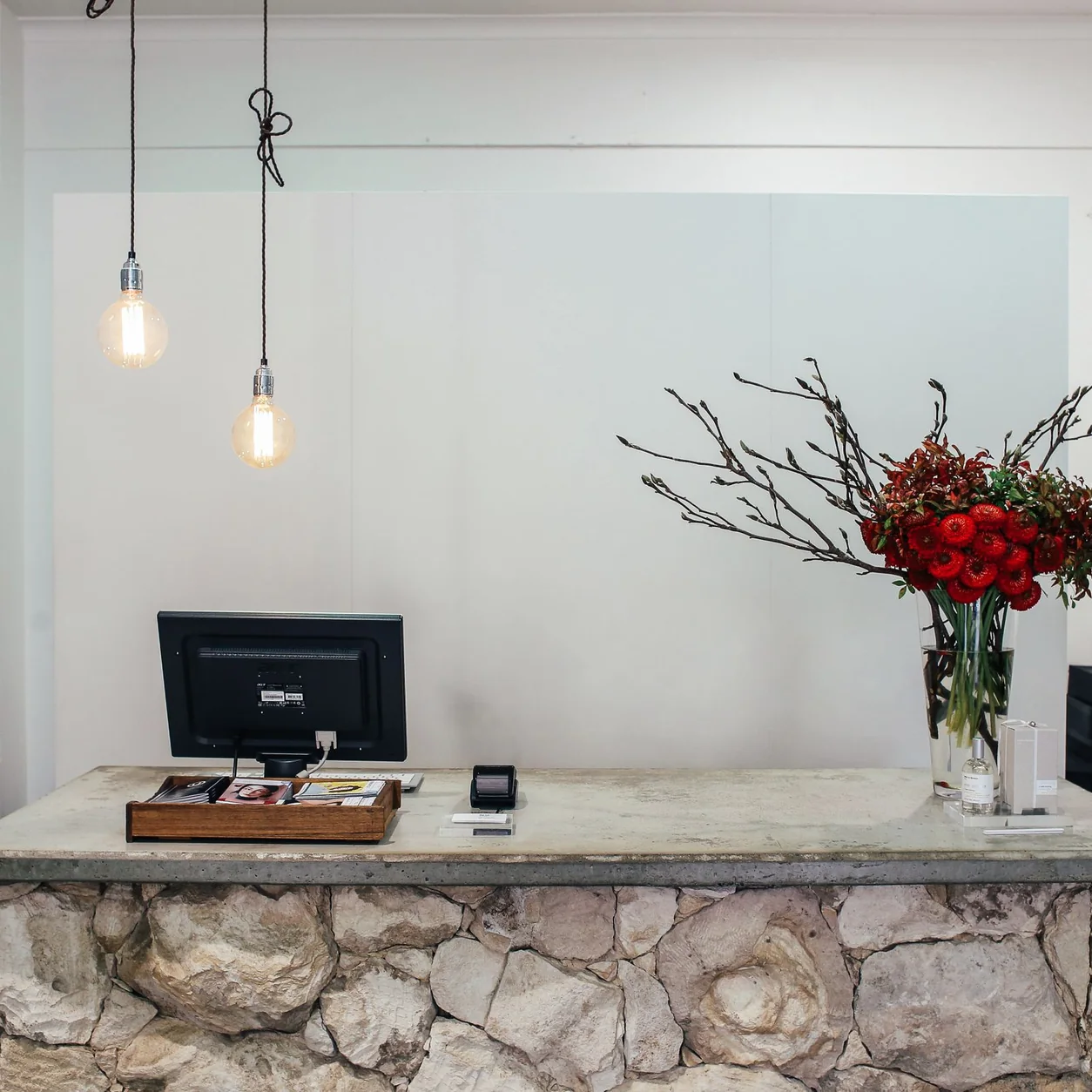 A white marble boutique counter with a floral arrangement.
