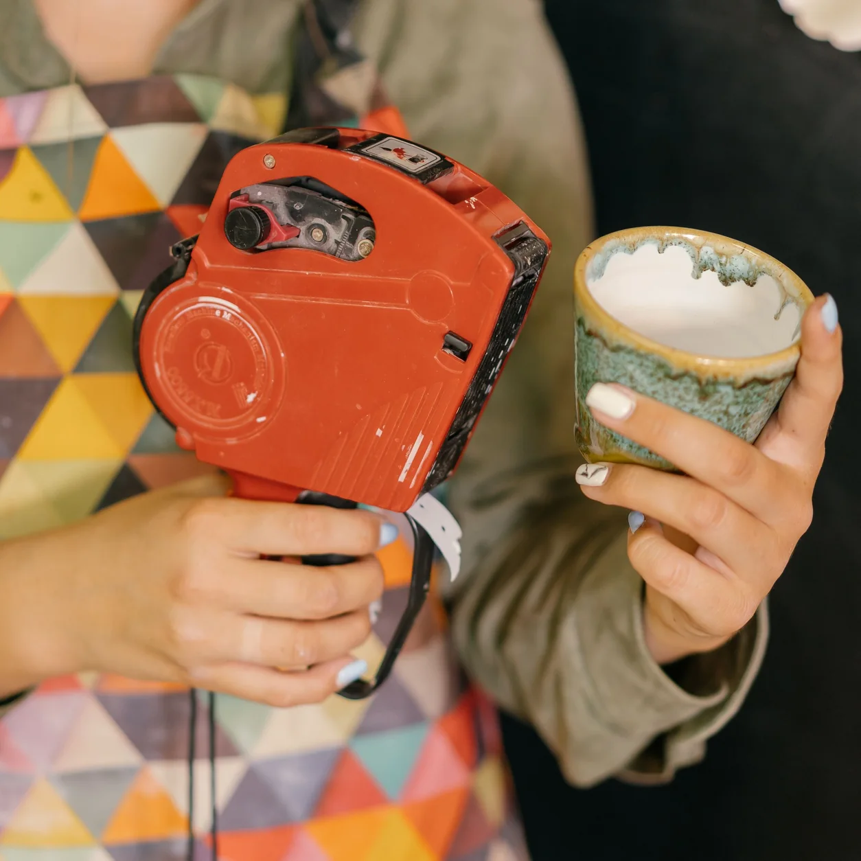 A maker adding a price tag to a handmade ceramic mug.