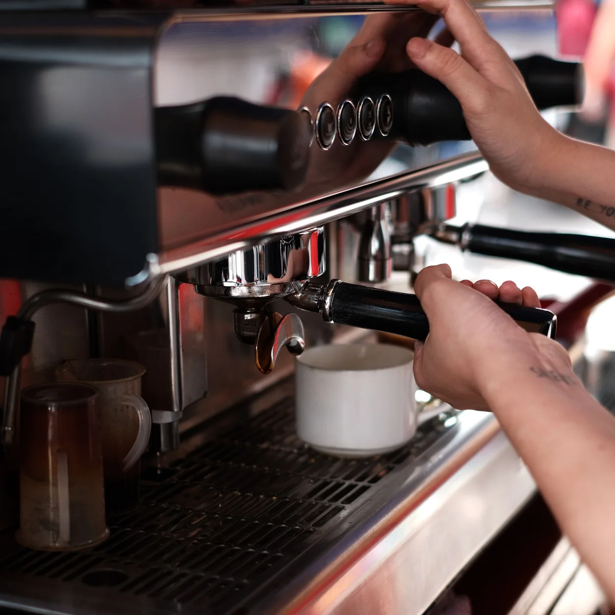 A barista preparing coffee at a professional espresso machine.