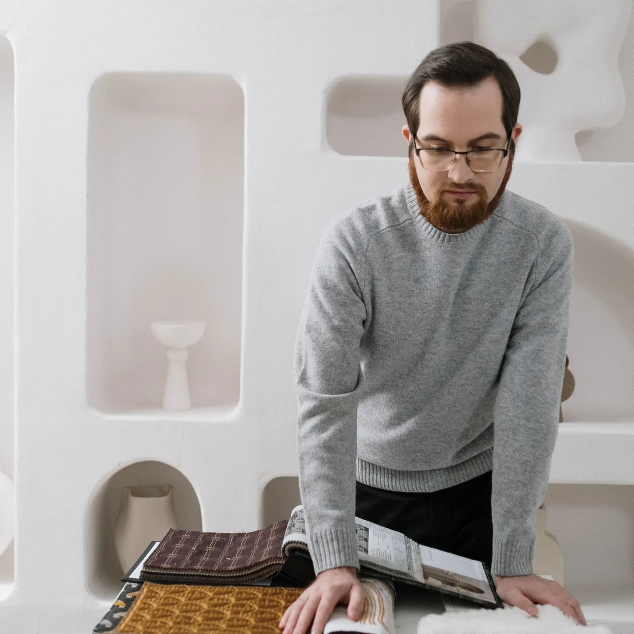 A designer reviewing fabric and material samples in a studio.