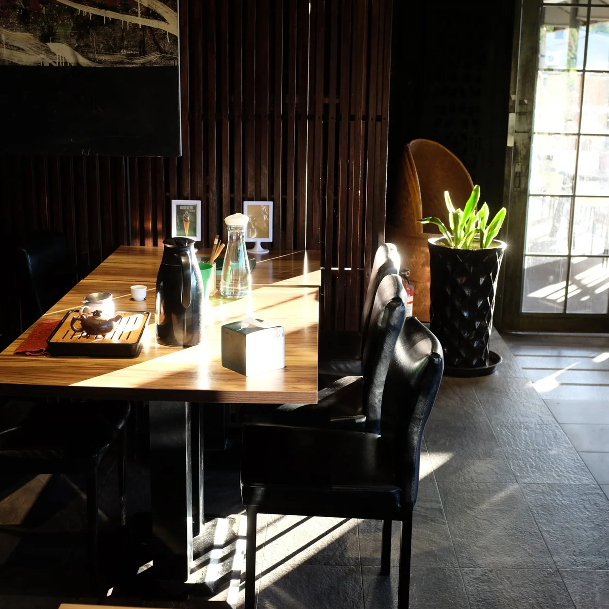 Sunlight across a restaurant table and leather chairs.