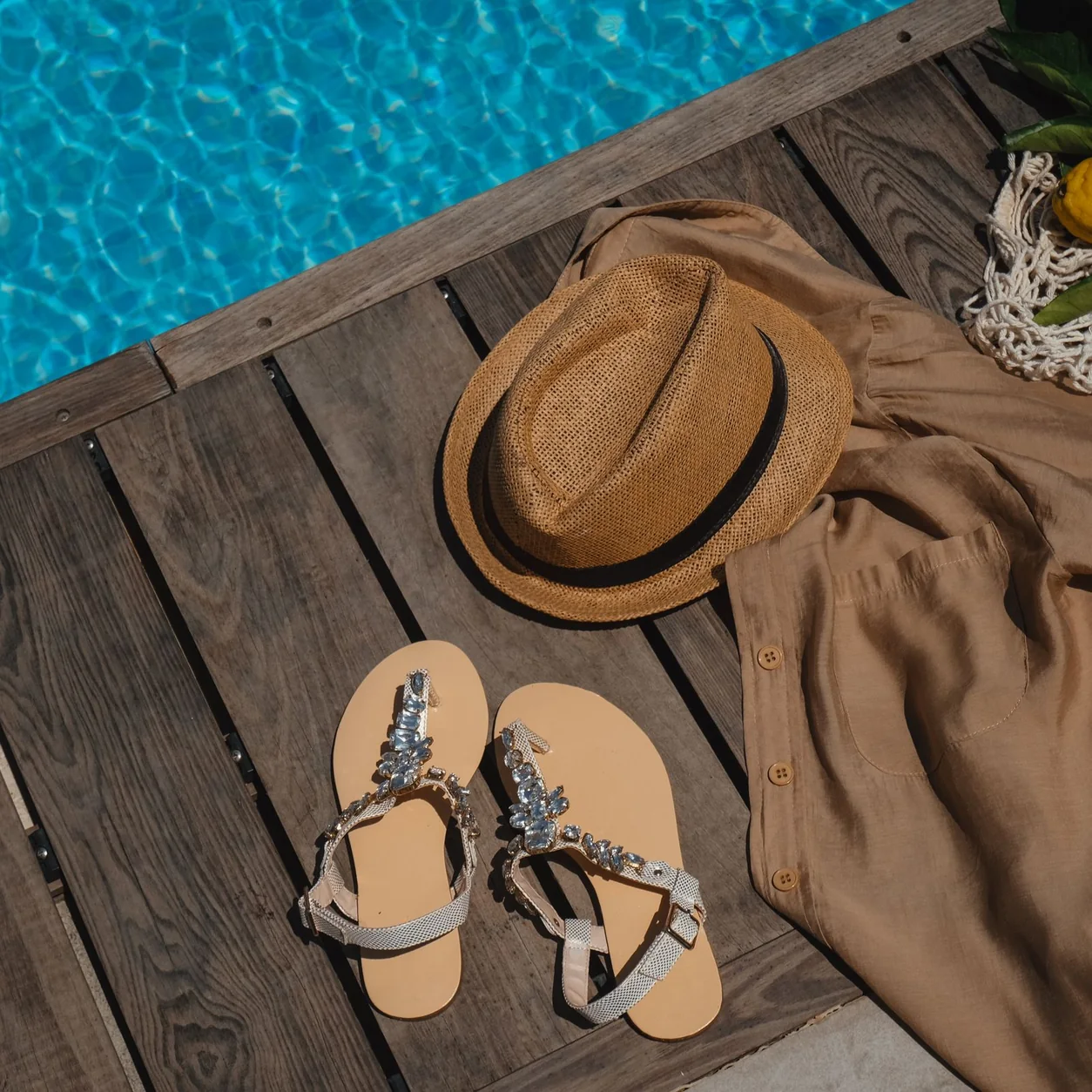Summer accessories arranged beside a blue swimming pool.