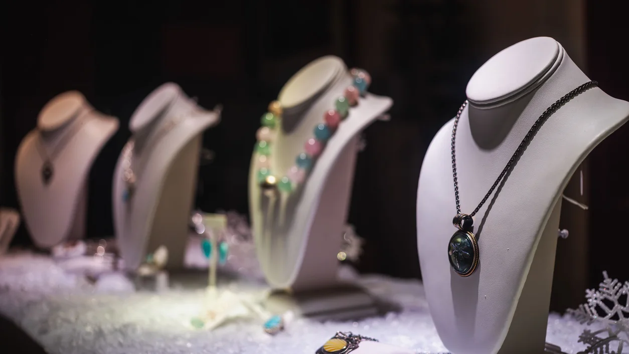 A refined display of luxurious necklaces on mannequins in a jewelry store.