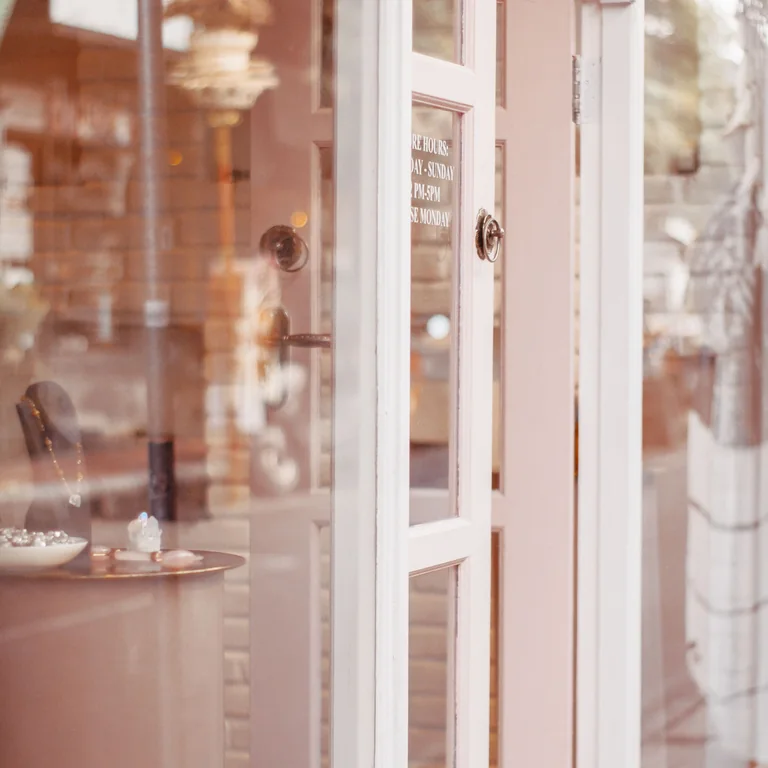 Elegant jewelry store entrance showcasing glass reflections and interior display.
