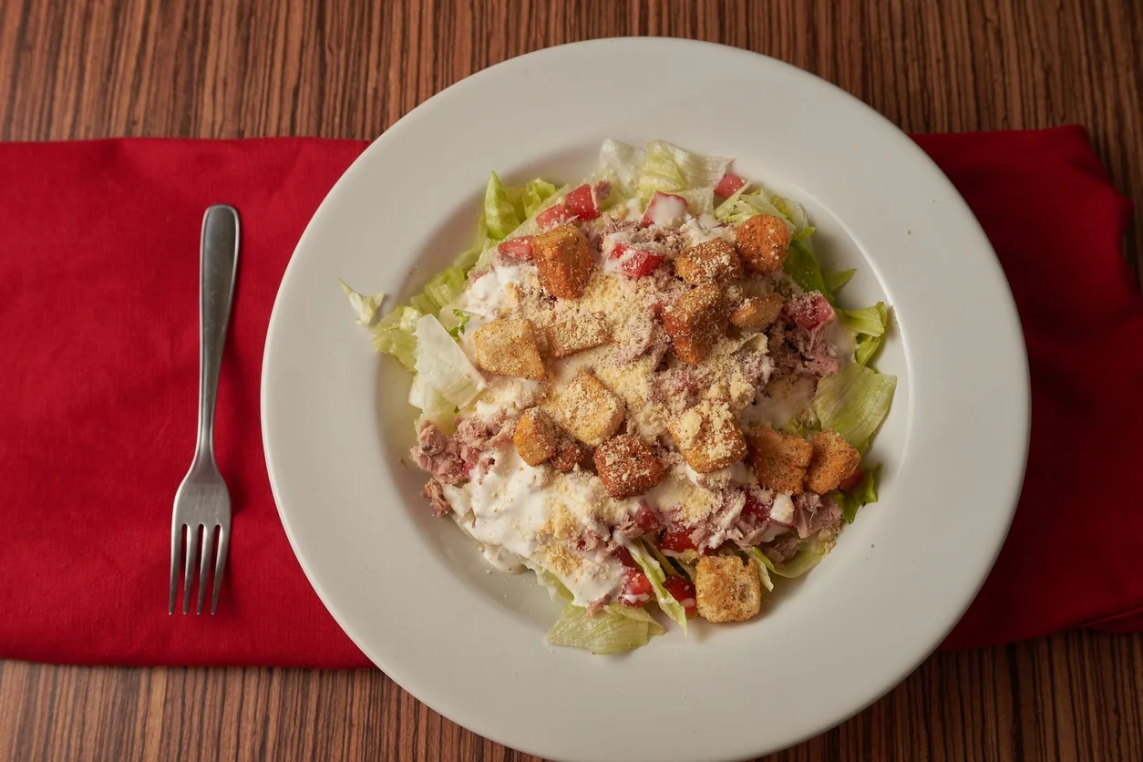 A plate of Caesar salad with parmesan and croutons.