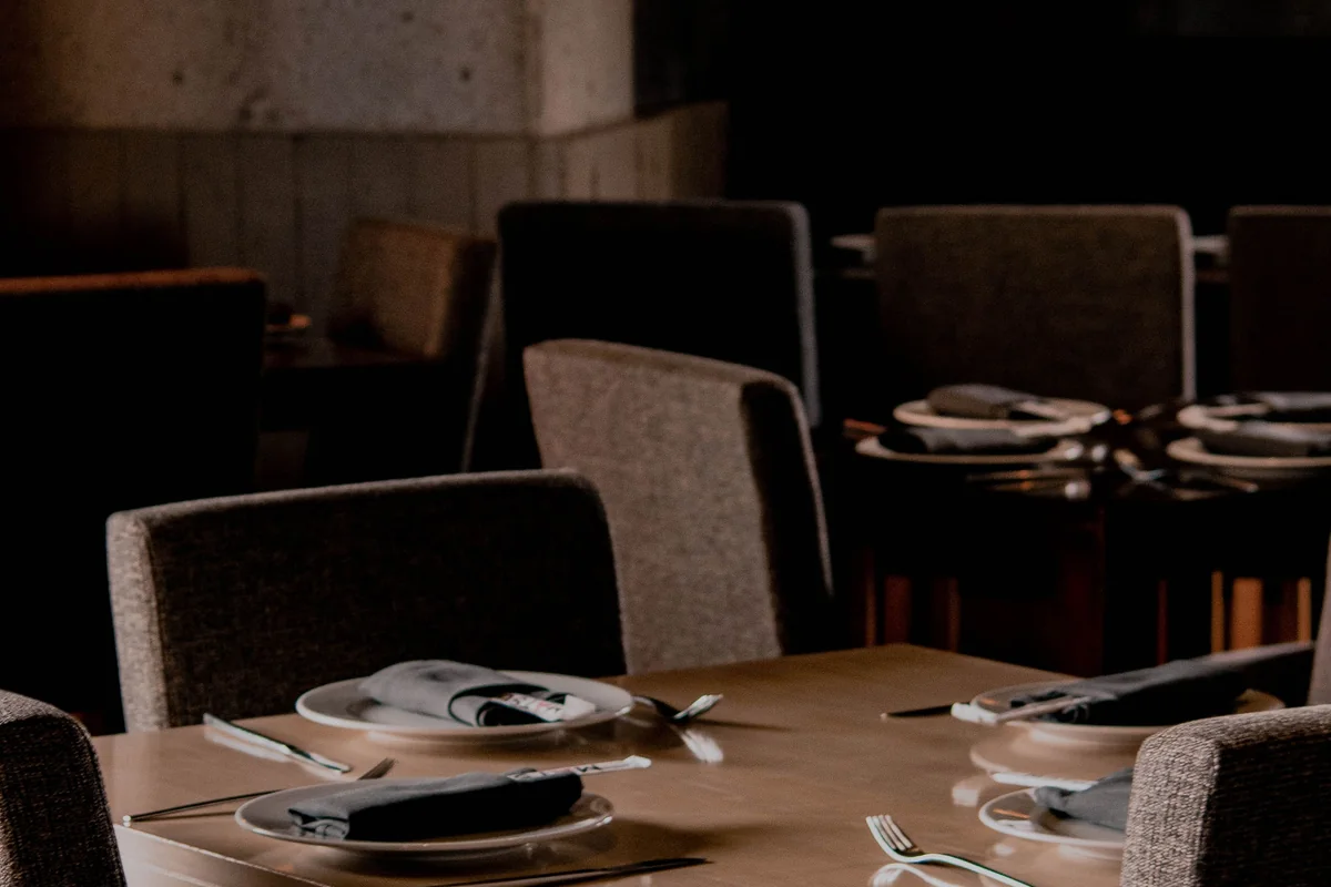 Chic restaurant setting with modern decor, chairs, and a beautifully set table ready for dining.